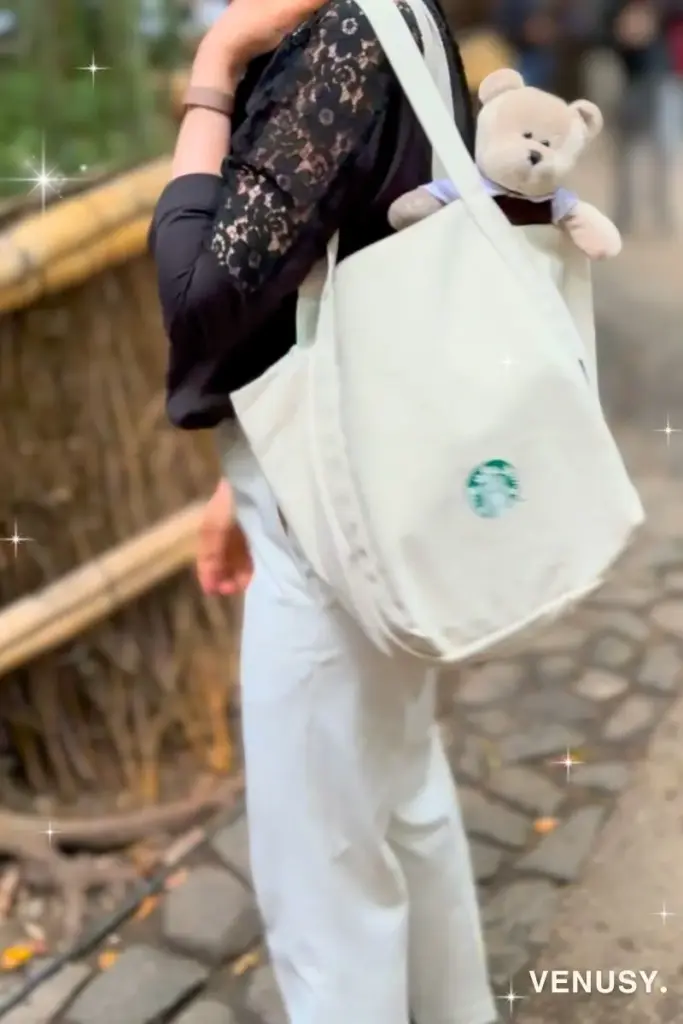 京都・嵐山竹林を背景に、スタバ福袋のトートからクーたんのぬいぐるみが顔を出している様子