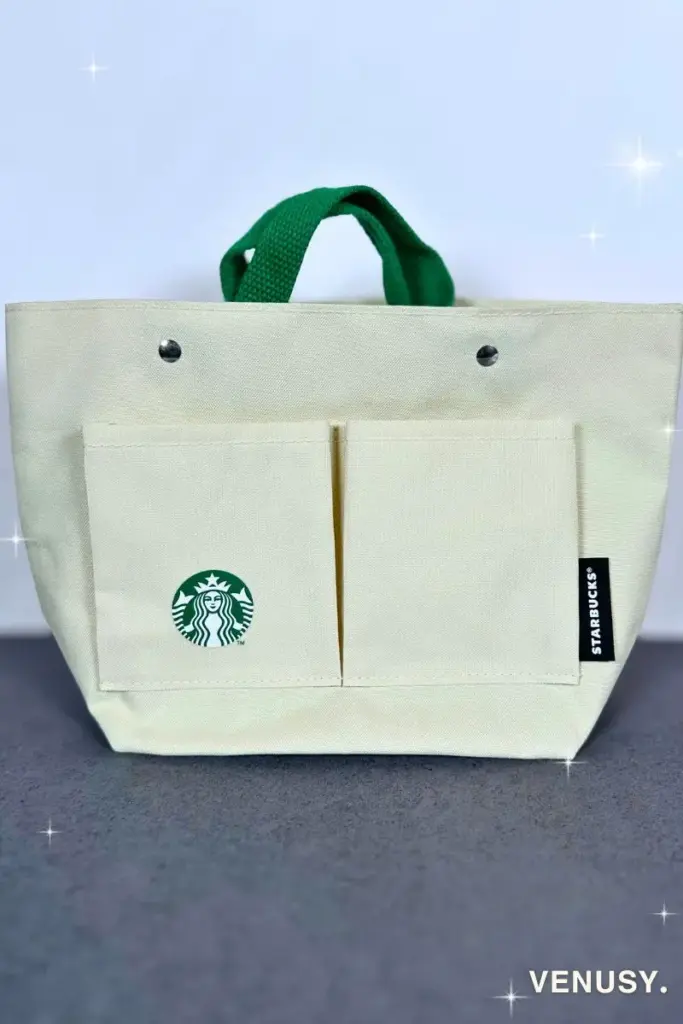 スターバックス福袋2025に入っていたバッグインバッグ。生成りのキャンバス生地にスタバのロゴ、前面ポケットと緑の持ち手が特徴の実用的なアイテム。